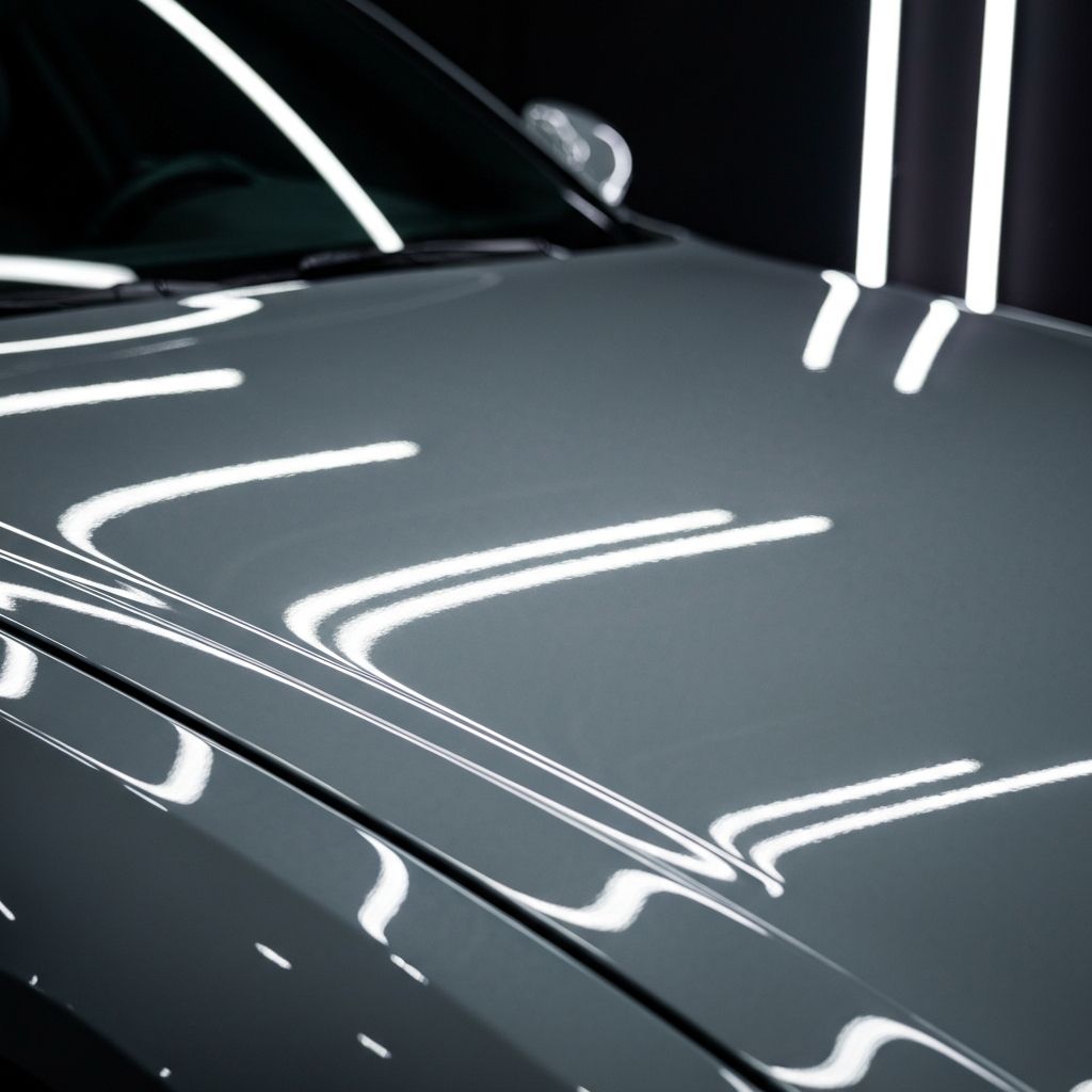 Professional detailing — clay bar treatment on a mirror-polished car panel